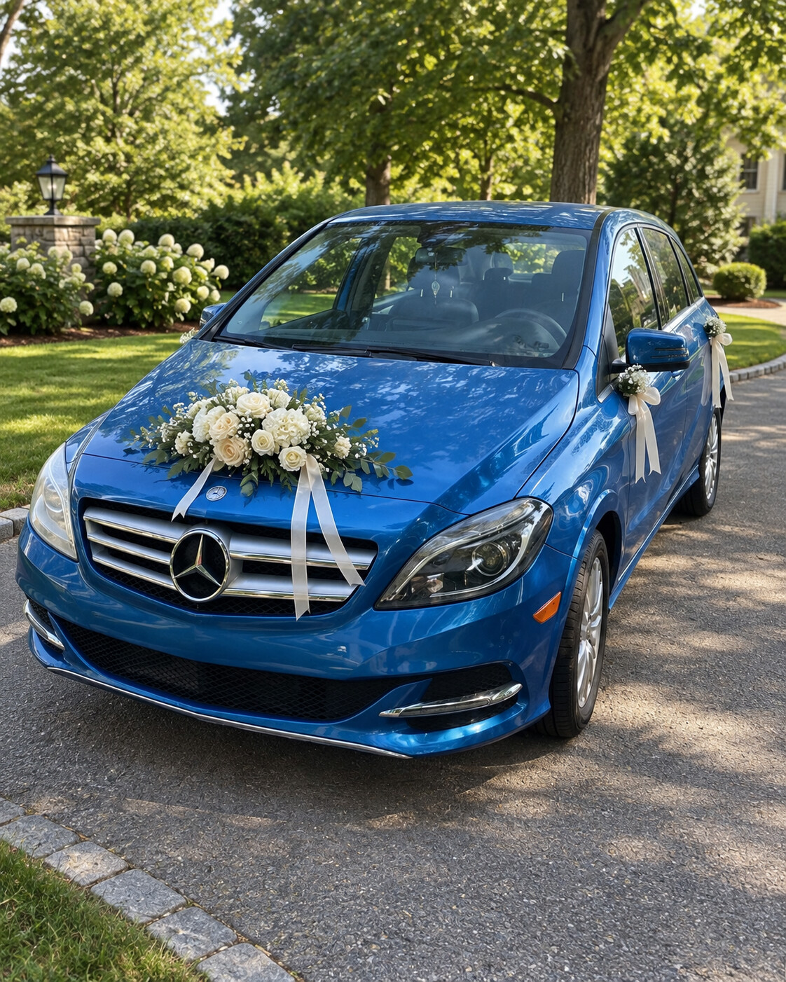 Blue modern Mercedes decorated with white wedding flowers